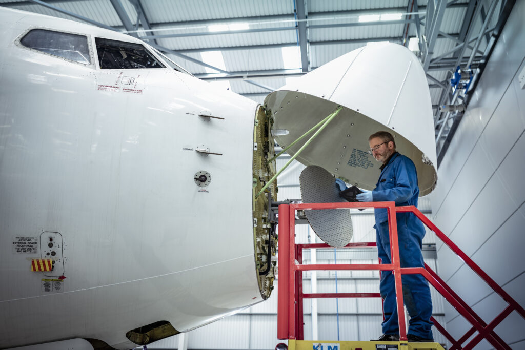 A male mechanic working on the nose of an aircraft